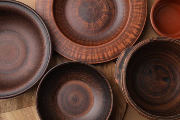 istock Ceramic bowls, wooden board and plate on beige background, flat lay 1917887231