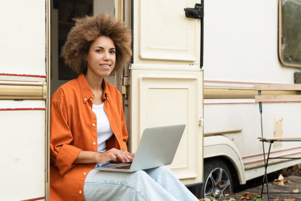 istock Thoughtful african young businesswoman student freelancer designer using laptop, working remotely online while travelling on van motor wheel home trailer. Solo trip adventurer 1917889827