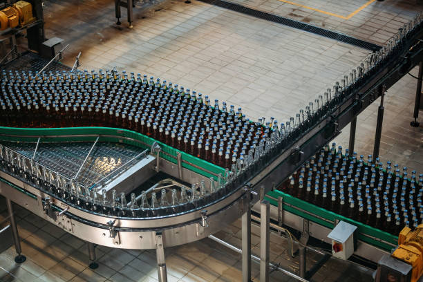 最新の自動ビール瓶詰め生産ライン。コンベア上を移動するビール瓶 - bottling plant bottle filling production line ストックフォトと画像