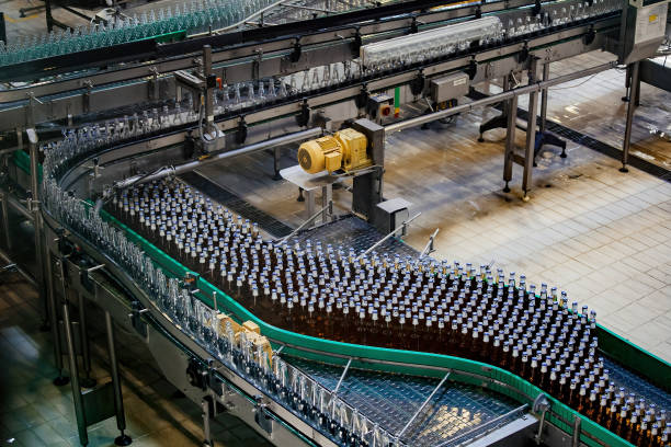 最新の自動ビール瓶詰め生産ライン。コンベア上を移動するビール瓶 - bottling plant bottle filling production line ストックフォトと画像