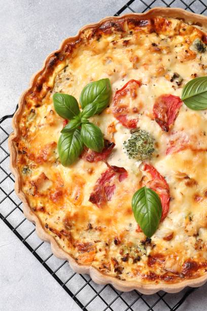 istock Tasty quiche with tomatoes, basil and cheese on light textured table, top view 1917913887