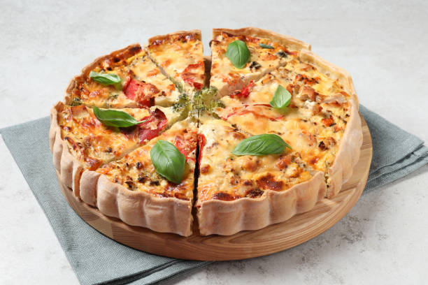 istock Tasty quiche with tomatoes, basil and cheese on light textured table, closeup 1917917058