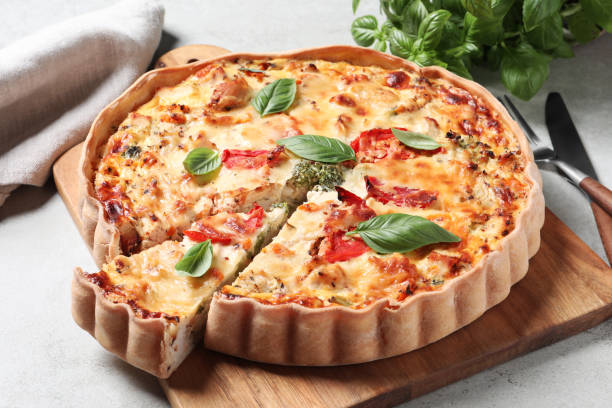 istock Tasty quiche with tomatoes, basil and cheese on light textured table, closeup 1917919331