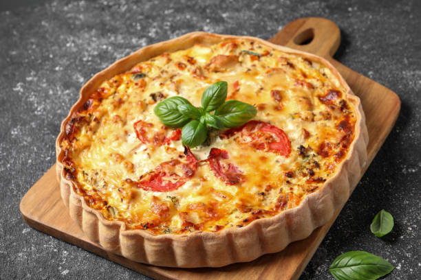 istock Tasty quiche with tomatoes, basil and cheese on dark textured table, closeup 1917920722