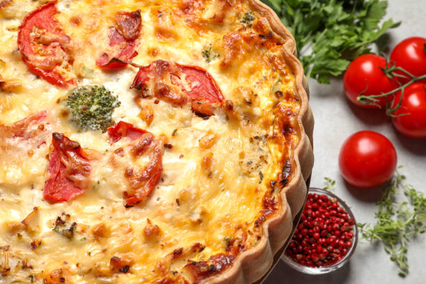 istock Tasty quiche with tomatoes and cheese served on light table, closeup 1917921757