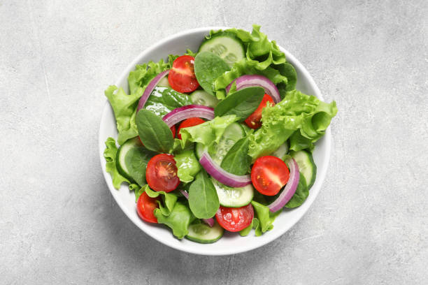 istock Delicious vegetable salad on light grey table, top view 1917941400