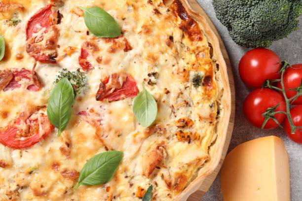 istock Tasty quiche with tomatoes, basil and cheese served on light table, flat lay 1917960196