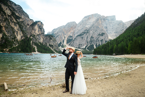 Female and male model in their wedding dress at lake braies in italy