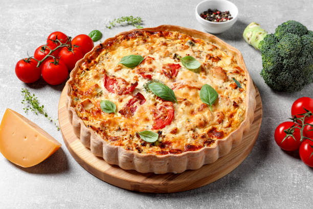 istock Tasty quiche with tomatoes, basil and cheese served on light table, closeup 1917963408