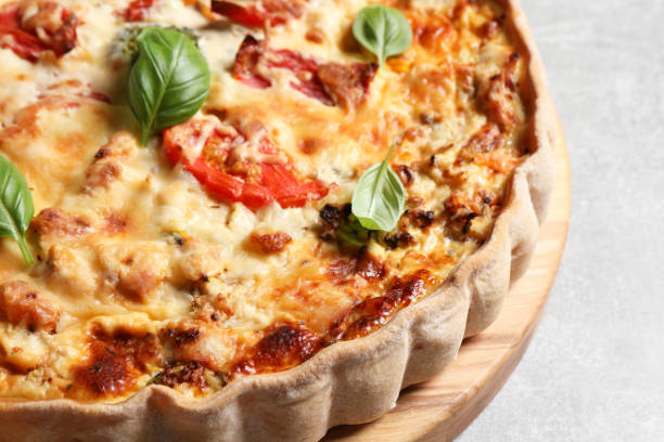 istock Tasty quiche with tomatoes, basil and cheese on light table, closeup 1917967081