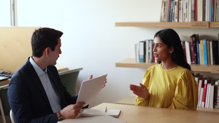 Hispanic HR manager interviewing young attractive Indian female applicant