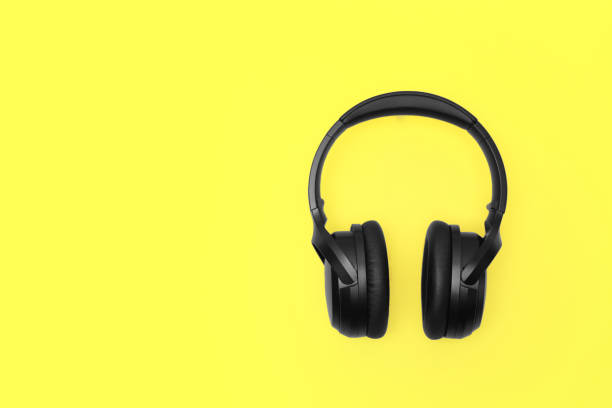 istock Modern wireless headphones on yellow background, space for text 1918026097