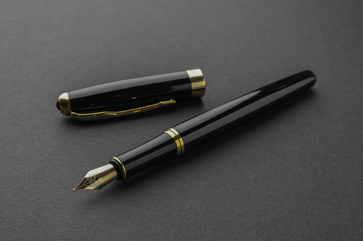 Stylish fountain pen with cap on black background