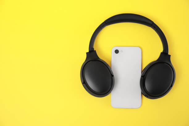 istock Modern wireless headphones and smartphone on yellow background, top view. Space for text 1918037608