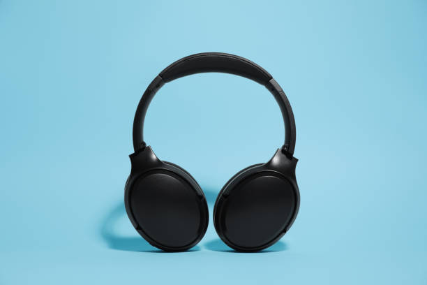 istock Modern wireless headphones on light blue background 1918038641