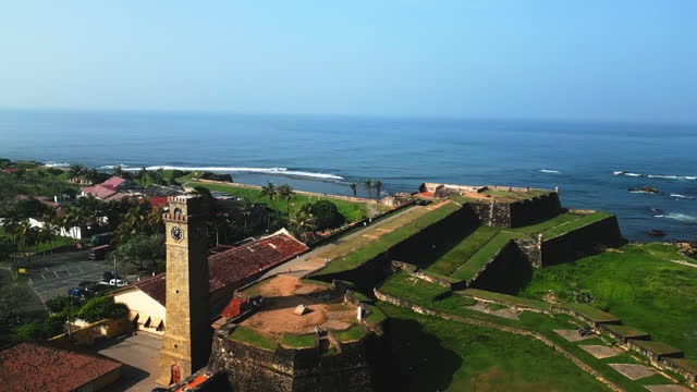 Drone view of Galle Fort, ancient architecture, coastal landmarks, Sri Lanka heritage site. Historic buildings, lighthouse, ramparts from above. Tourist destination, aerial cityscape.