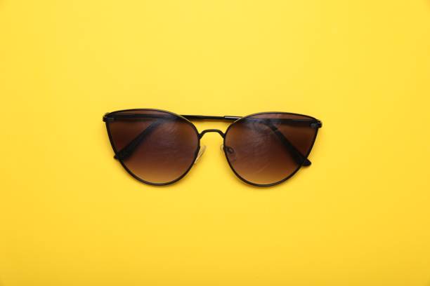 istock Stylish sunglasses on yellow background, top view 1918049571