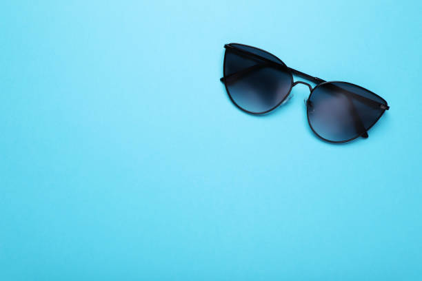 istock Stylish sunglasses on light blue background, top view. Space for text 1918050609