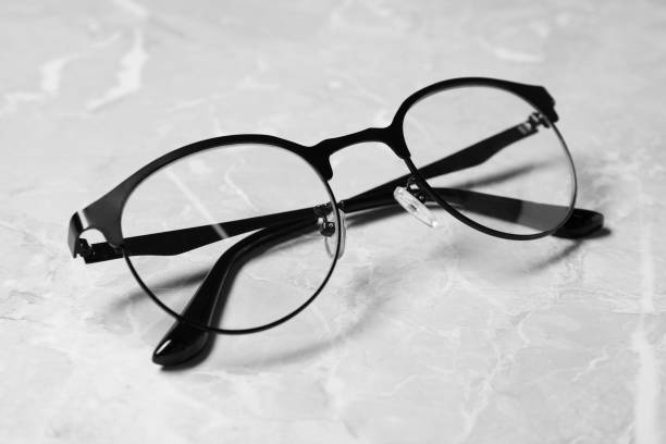 istock Glasses in stylish frame on grey marble table, closeup 1918055384