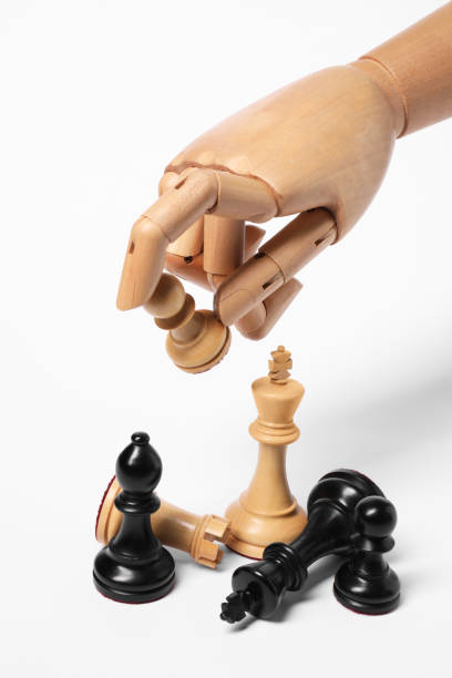 istock Robot holding pawn over other chess pieces on white background. Wooden hand representing artificial intelligence 1918073656