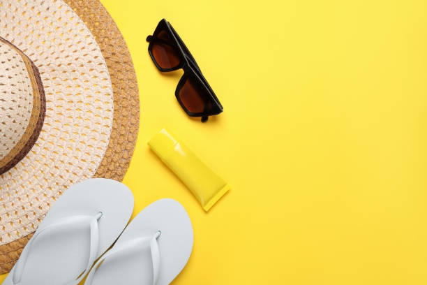 istock Flat lay composition with sunscreen and beach accessories on yellow background. Space for text 1918073671