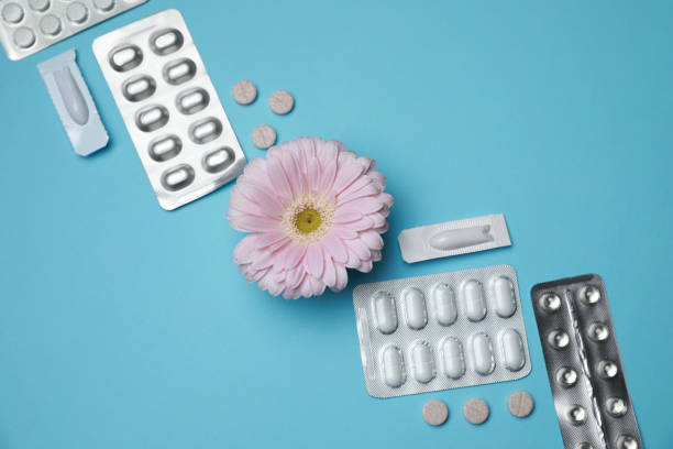 istock Many gynecological pills and gerbera flower on light blue background, flat lay 1918079491