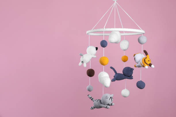 istock Cute baby crib mobile on pink background. Space for text 1918080026