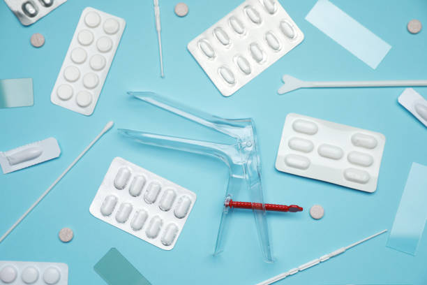 Sterile gynecological examination kit and pills on light blue background, flat lay