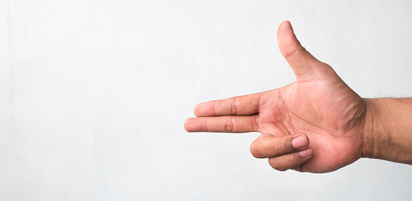 man's hand forming a gun concept pointing or shooting isolated white background