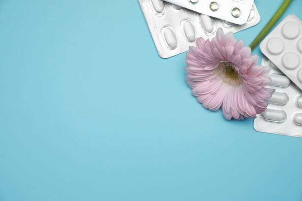 istock Many gynecological pills and gerbera flower on light blue background, flat lay. Space for text 1918082760