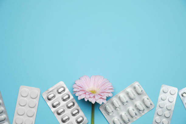 istock Many gynecological pills and gerbera flower on light blue background, flat lay. Space for text 1918082773