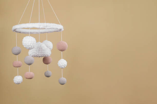 istock Cute baby crib mobile on beige background. Space for text 1918093028