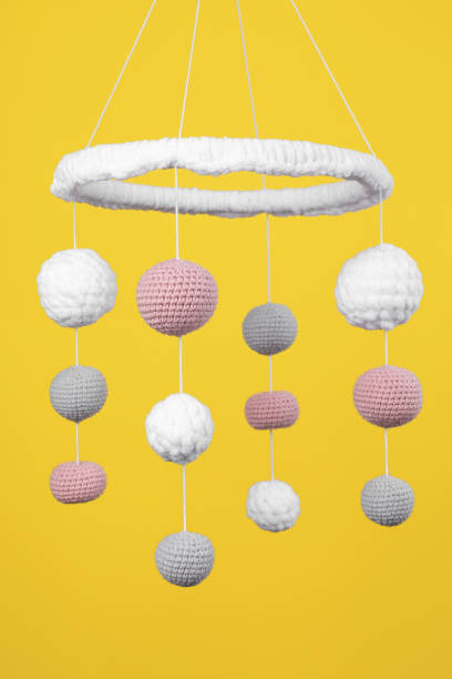 istock Cute baby crib mobile on yellow background 1918093050