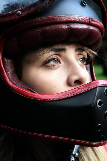 White racing car helmet and racing gloves sat on the roof of a racing car - awaiting the start of the race.
