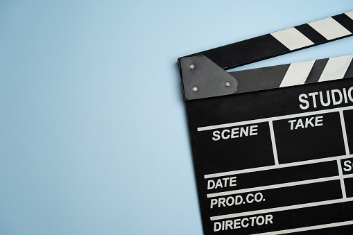 close up movie clapper on blue table background ; film, cinema and video photography concept