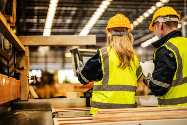 istock back of Factory engineer workers standing to control panel switch. people works at heavy machine at industry factory. with machinery equipment plant technology. smart industry worker operating. 1918135009
