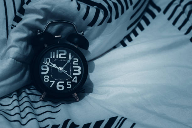 istock Black alarm clock on the bed. Time to sleep 1918156920