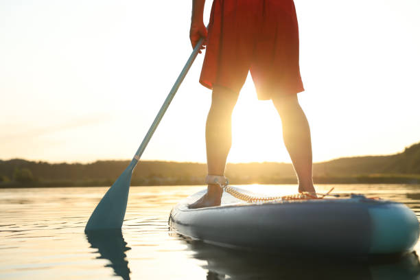 istock Man paddle boarding on SUP board in river at sunset, closeup 1918156938
