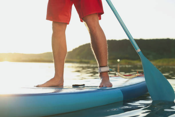istock Man paddle boarding on SUP board in river at sunset, closeup 1918158146