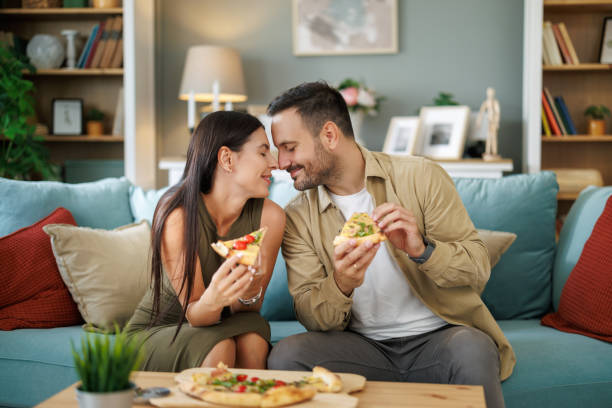 istock Couple eating pizza at home 1918159032