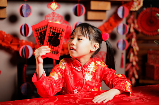 medium shot of young Chinese girl celebrating Chinese new year at home