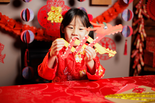 medium shot of young Chinese girl celebrating Chinese new year at home