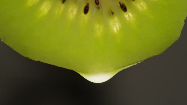 Kiwi with water close-up macro. Slice fresh exotic kiwi fruit texture background . Health fruits concept.