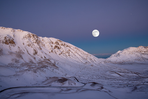 Situazione di luce particolare al tramonto sul gransasso mentre è appena sorta la luna del Castoro.