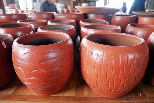 Handmade ceramic clay terracotta jugs, pots, vases, souvenirs on shelves in street craft pottery shop. Clay brown ceramic pot jug