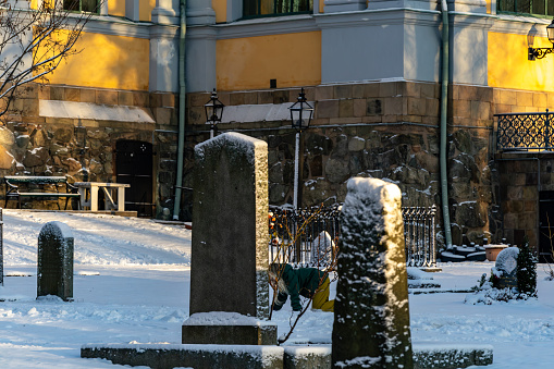 Stockholm, Sweden, Dec 24, 2023 A child on all fours plays in the Katarina Church  cemetery in the winter snow.