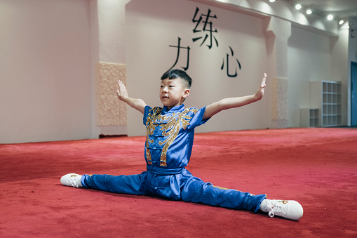 Young Chinese boy practising Wushu in a gym