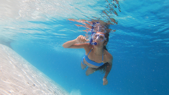 Teen girl snorkelling in clear blue water