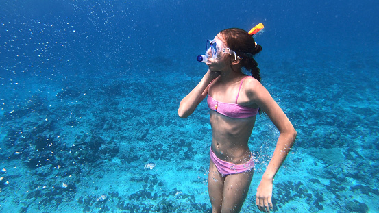 Teen girl snorkelling around the coral reef