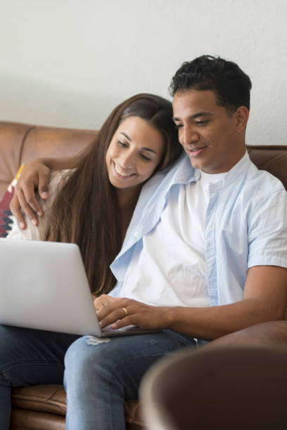 istock Young couple moving to a new home relaxing sitting on the sofa using computer laptop, smiling happy for moving to new apartment 1918358664